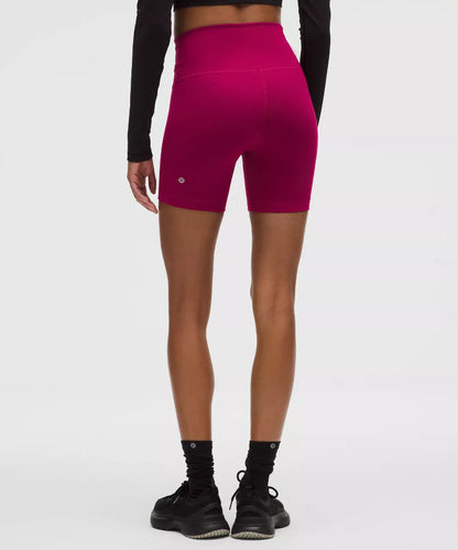 Person wearing bright pink athletic shorts on a white background