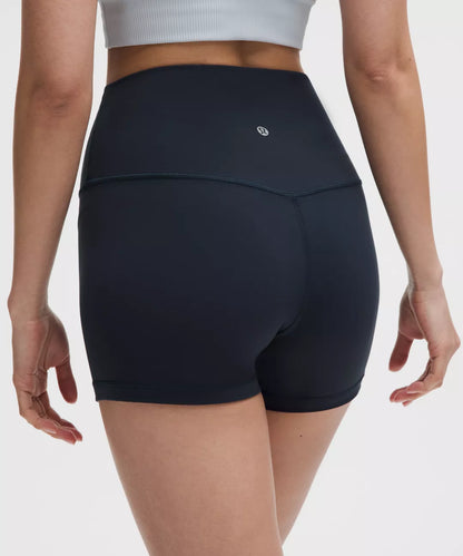 Person wearing black athletic shorts on a plain background
