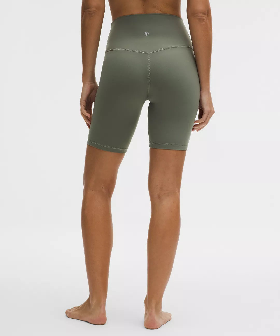 Person wearing green athletic shorts on a white background