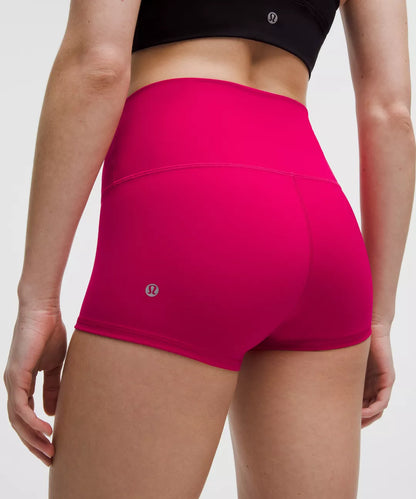Person wearing bright pink athletic shorts with a white background