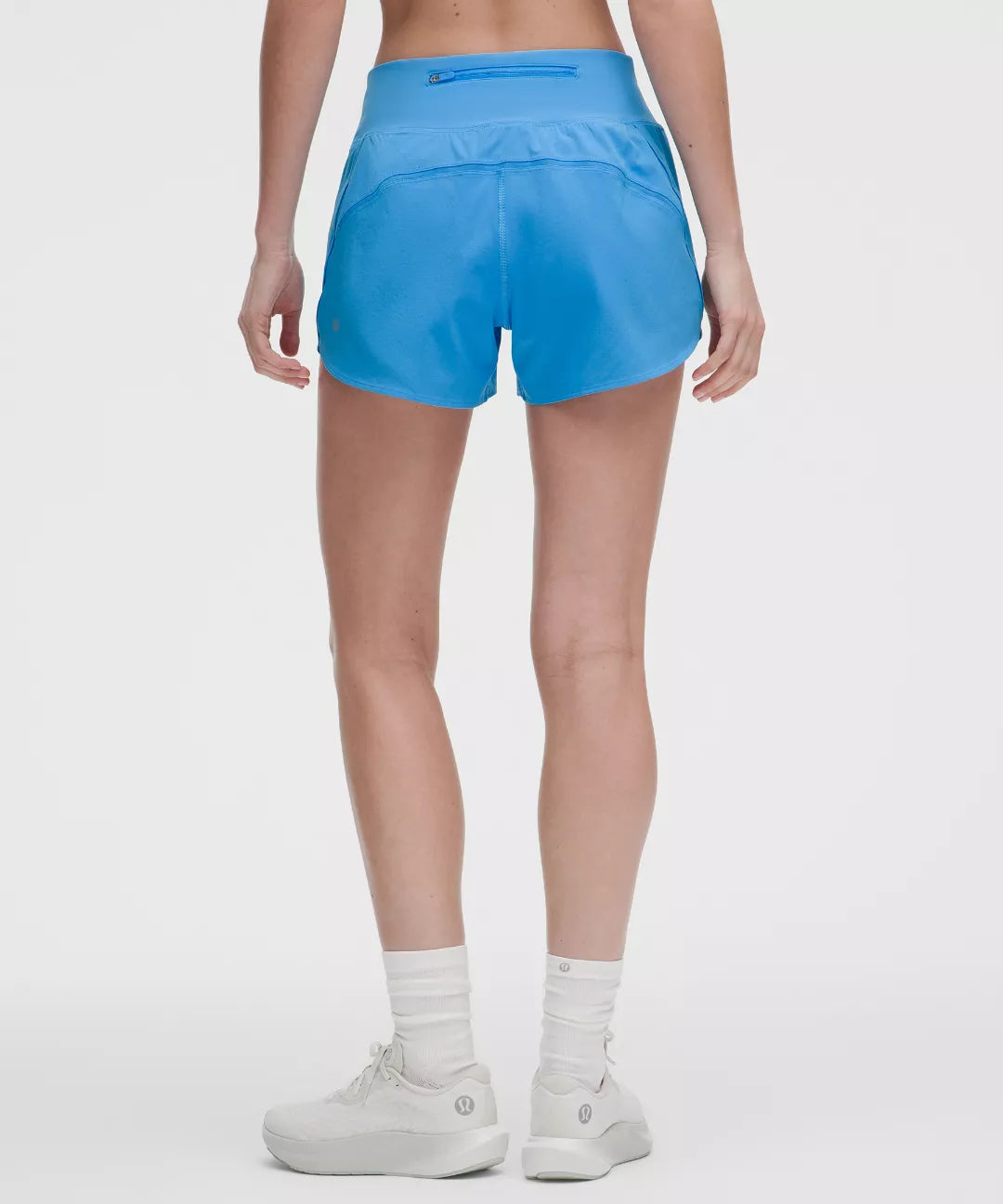 Person wearing blue athletic shorts on a white background