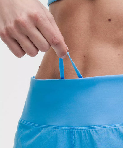 Person wearing a blue athletic outfit with a close-up of the waistband.