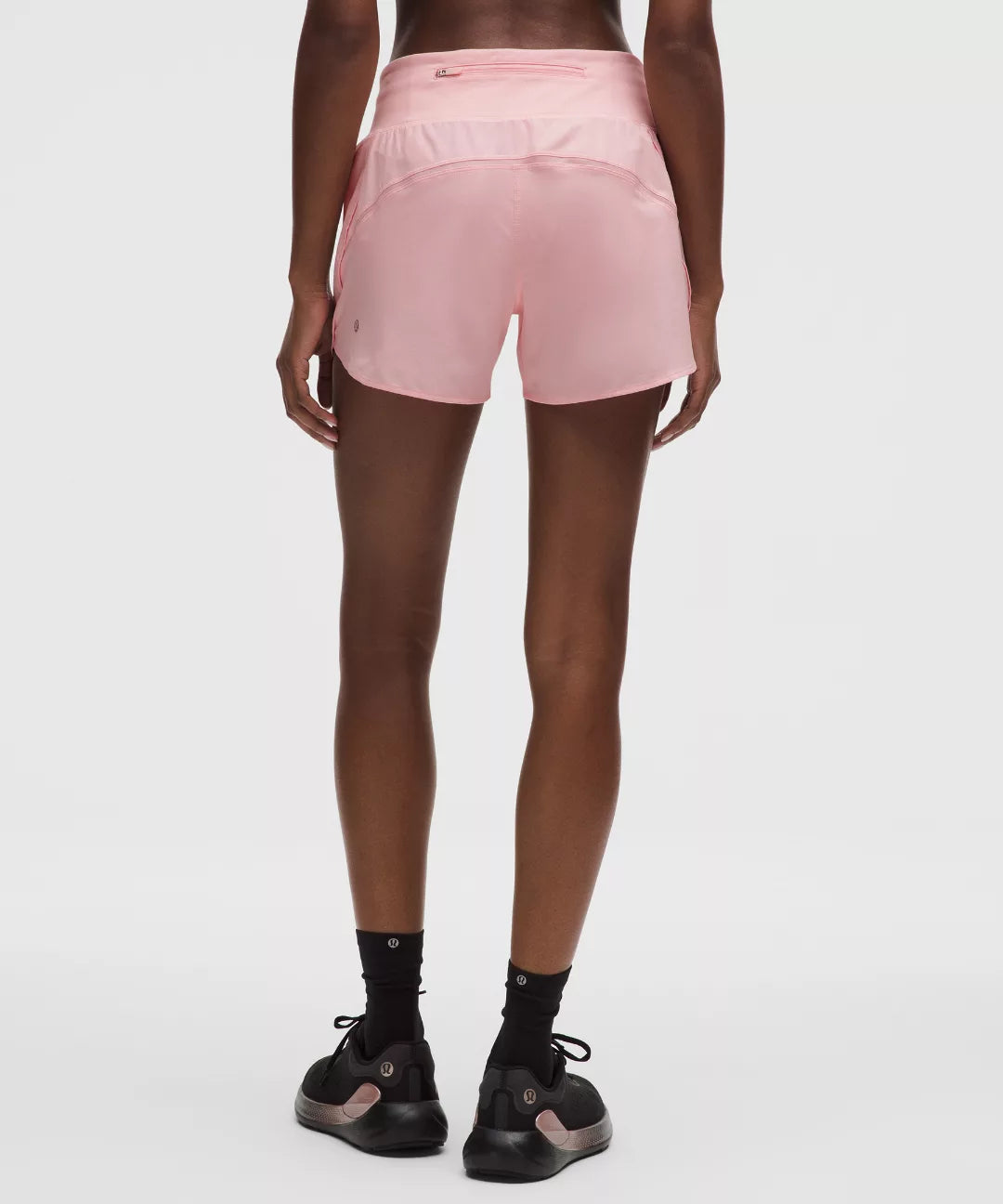 Person wearing pink athletic shorts on a white background