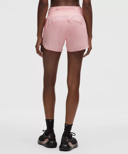 Person wearing pink athletic shorts on a white background