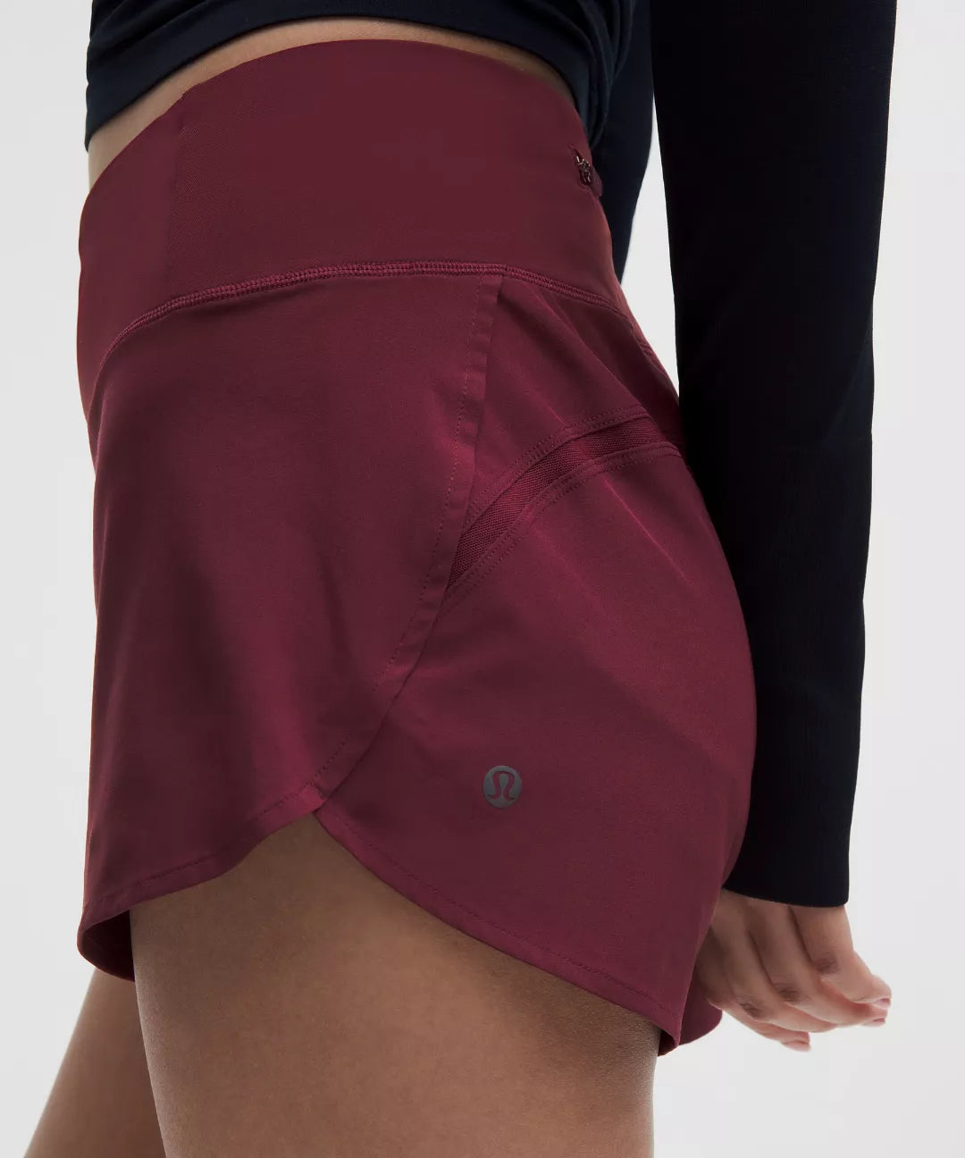 Maroon athletic shorts worn by a person on a white background