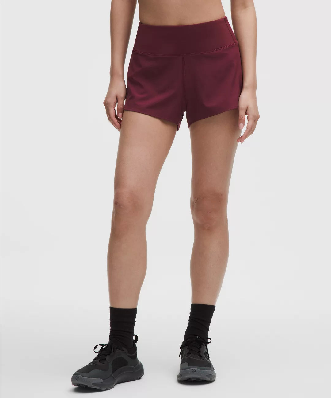 Maroon athletic shorts worn by a person on a white background