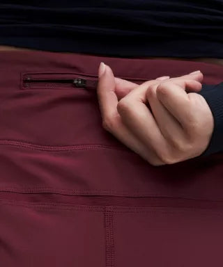 Close-up of a hand interacting with a zipper on a dark jacket.