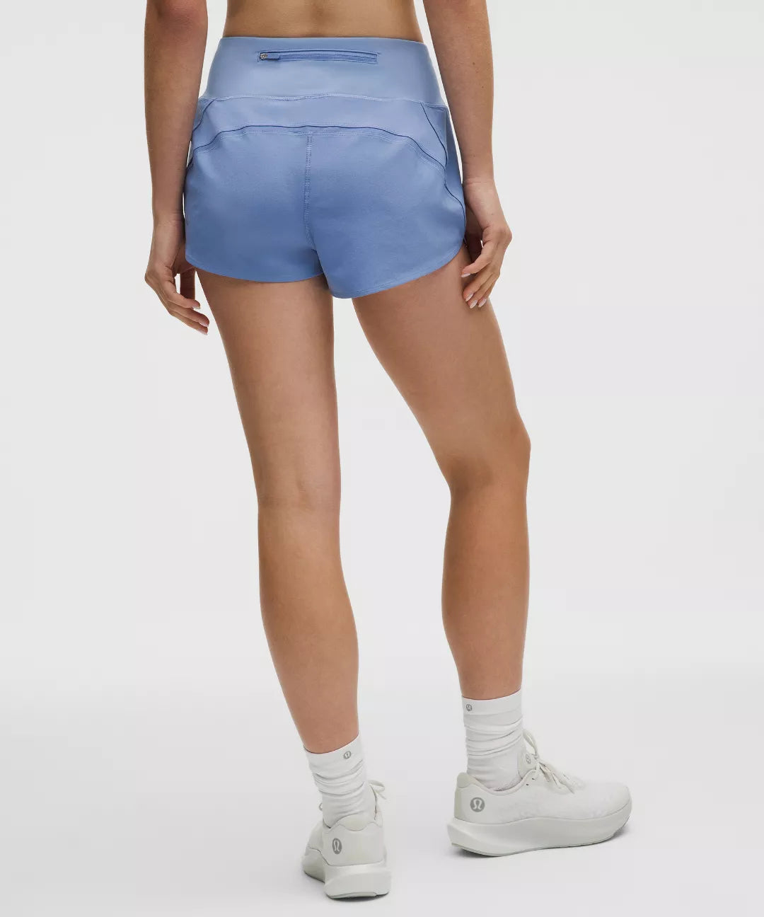 Person wearing light blue athletic shorts on a white background