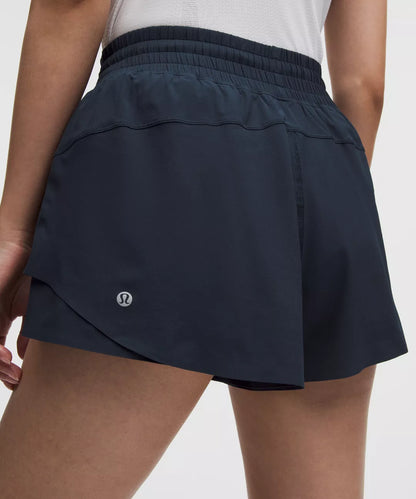Navy blue athletic shorts with a brand logo on a neutral background