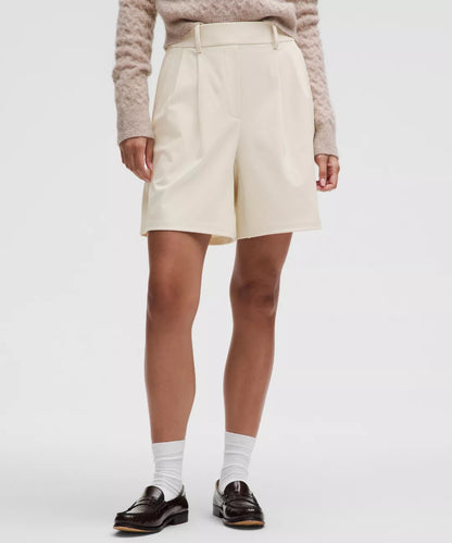 Person wearing a beige skirt with a plain background