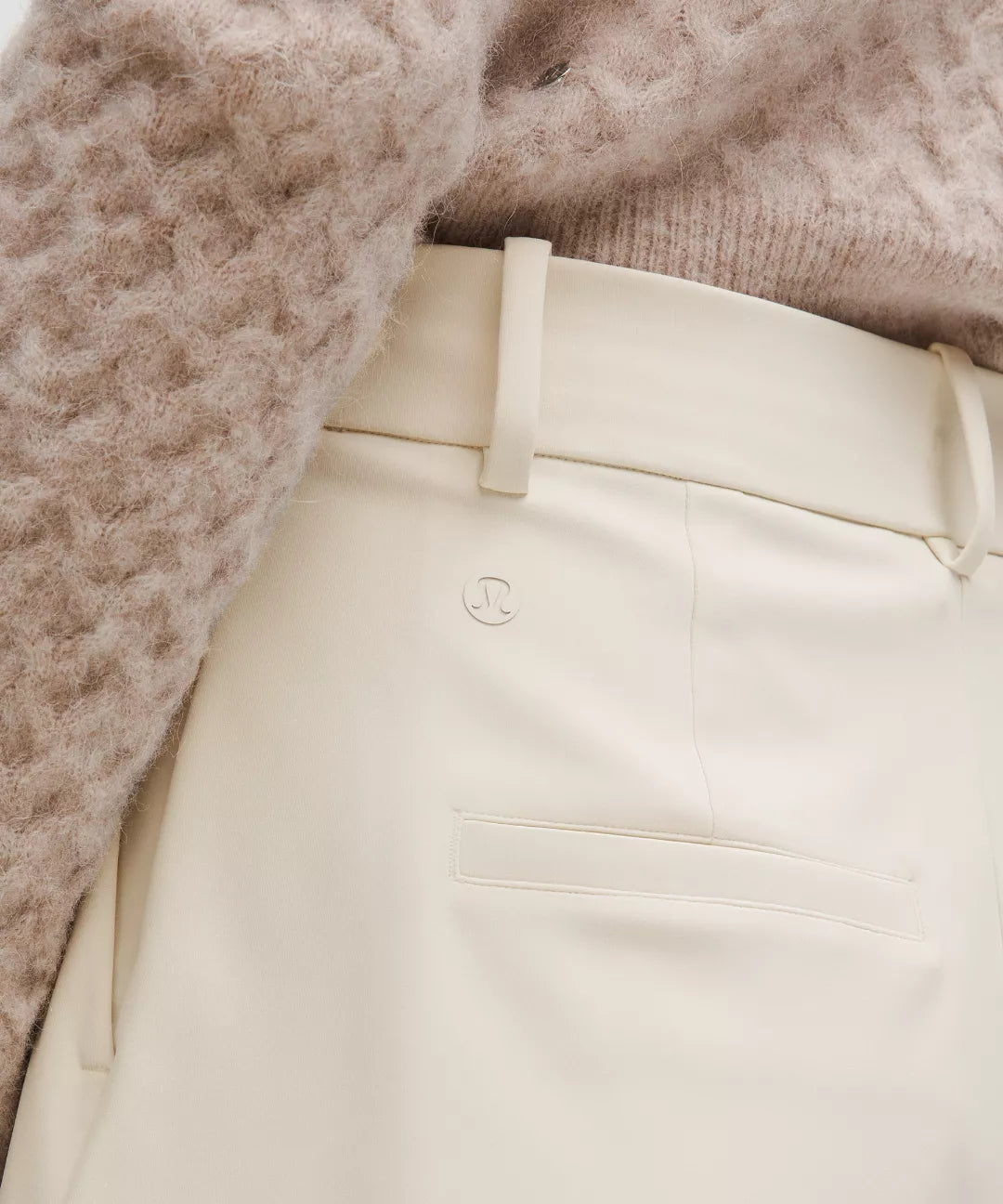 Close-up of beige pants with a textured brown sweater.