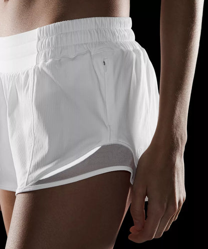 White athletic shorts worn by a person on a black background