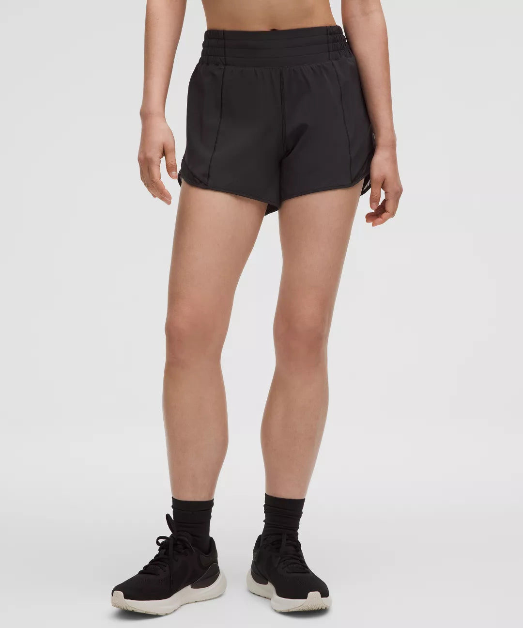 Person wearing black athletic shorts on a white background
