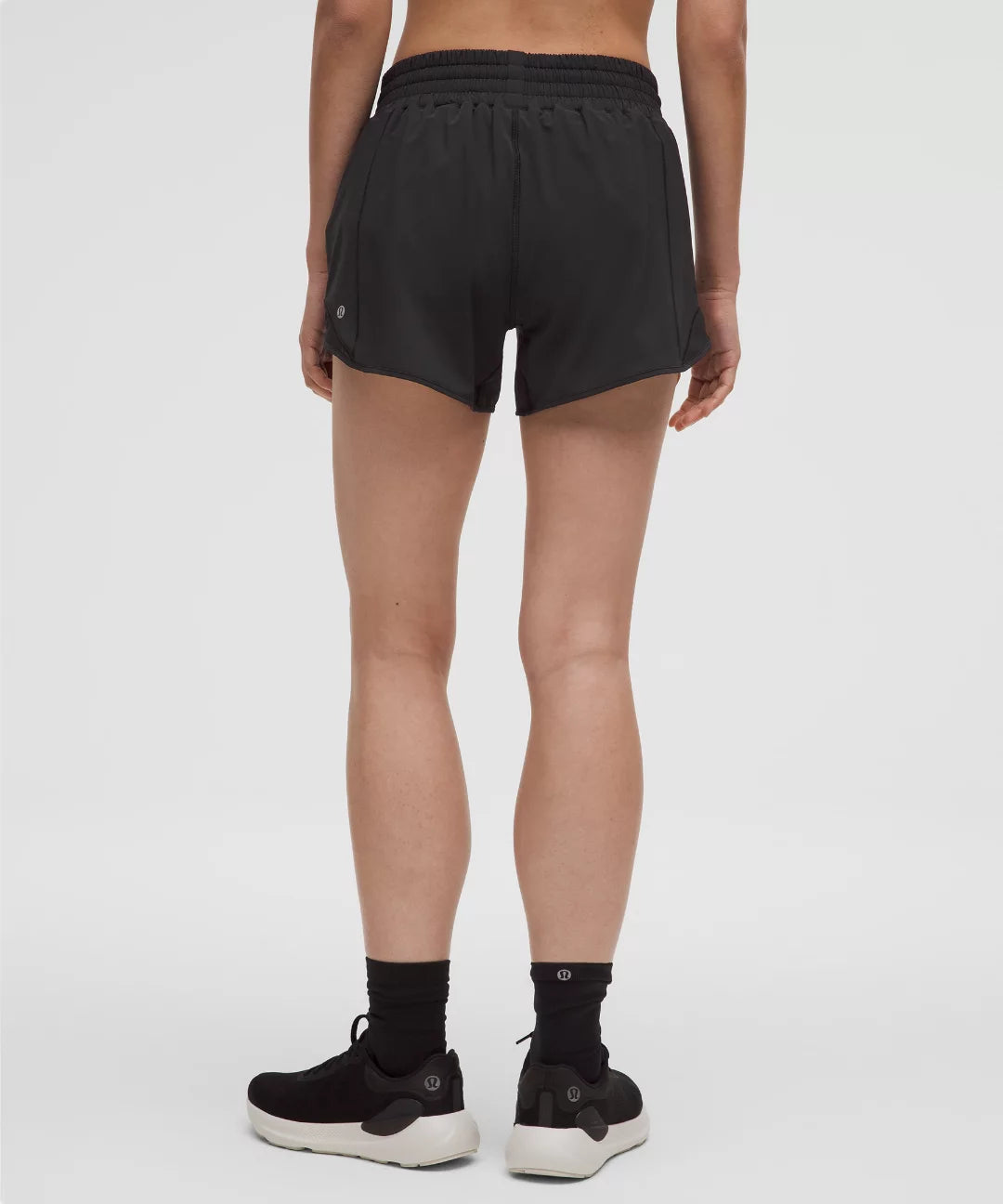 Person wearing black athletic shorts on a white background