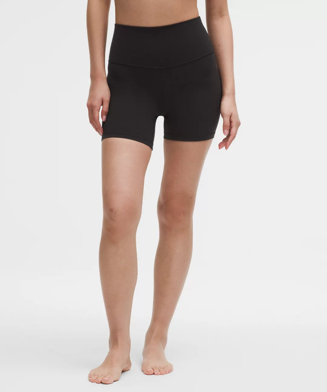 Person wearing black athletic shorts on a white background