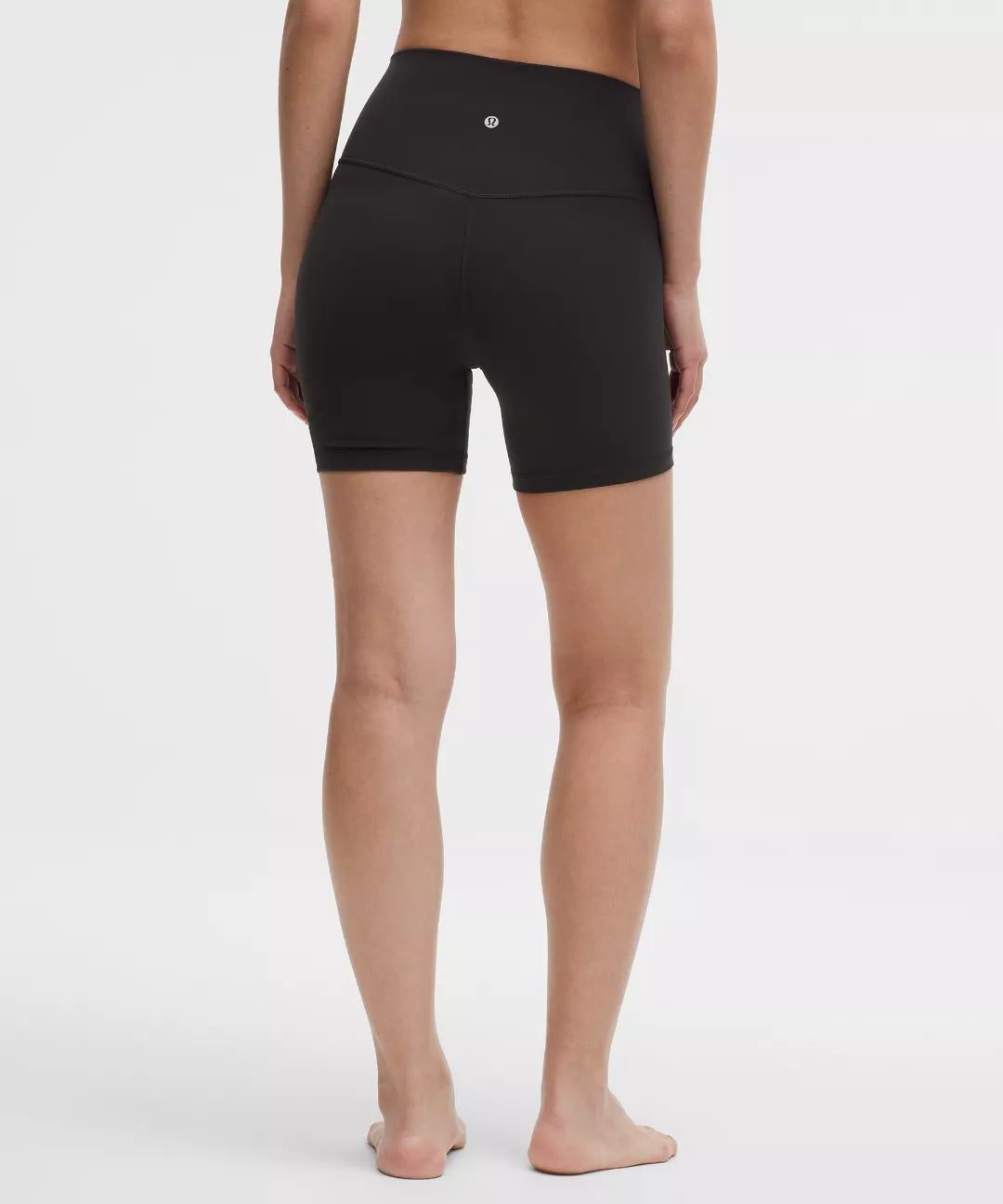 Person wearing black athletic shorts on a white background