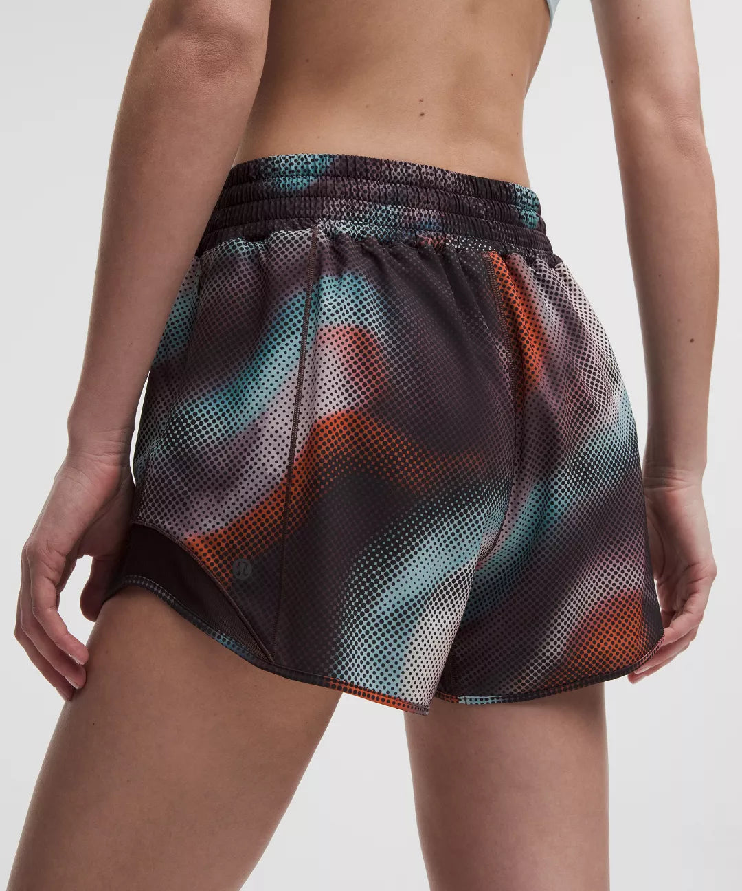 Multicolored mesh shorts worn by a person on a white background
