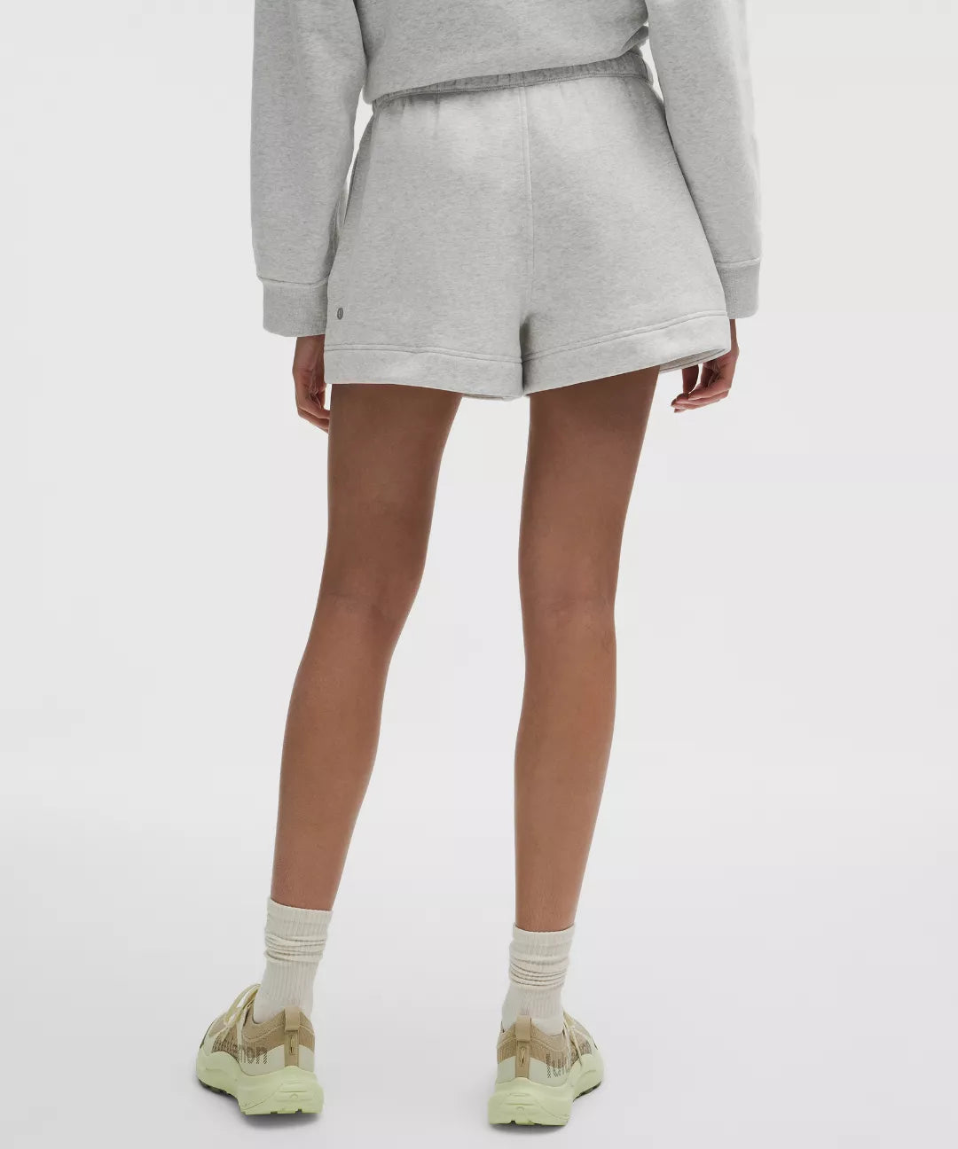 Person wearing a gray outfit with shorts on a white background