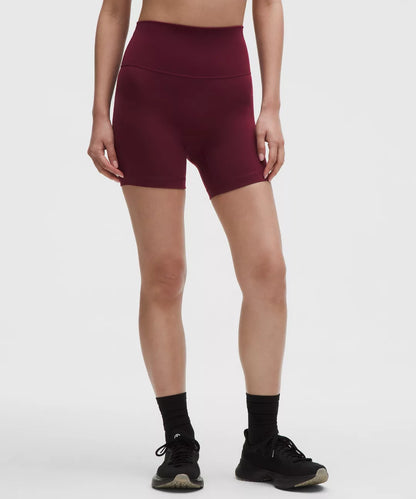 Person wearing maroon athletic shorts on a white background