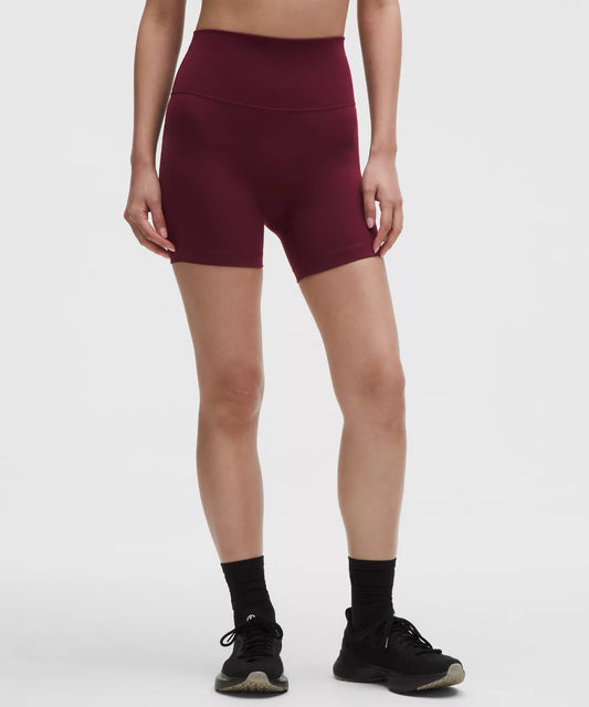 Person wearing maroon athletic shorts on a white background