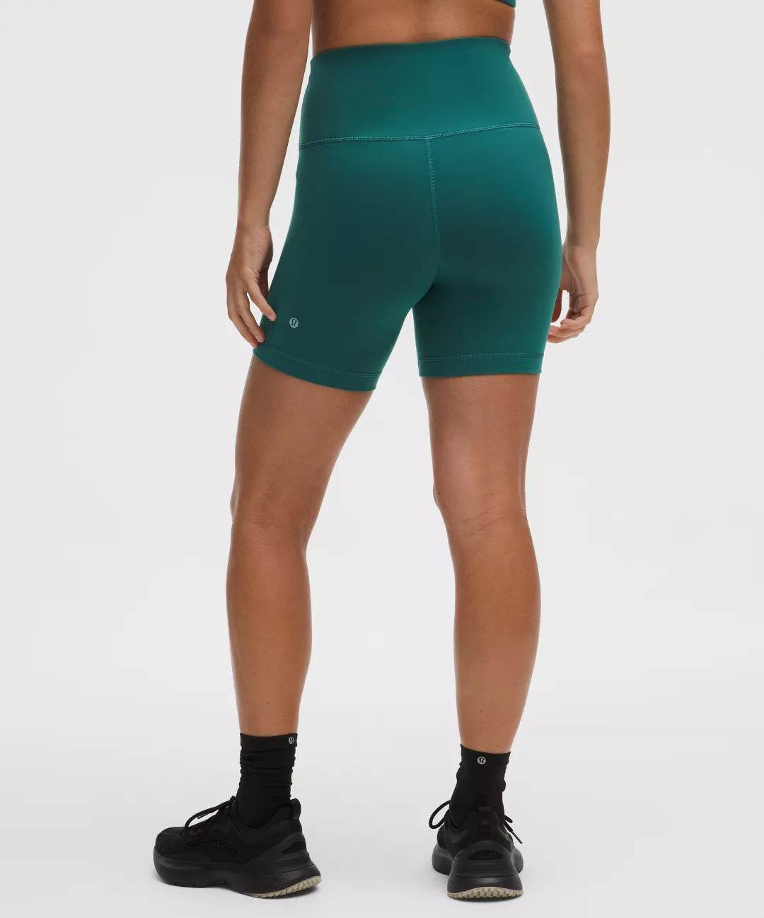 Person wearing teal athletic shorts on a white background