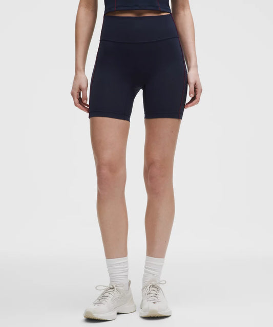 Person wearing navy blue athletic shorts on a white background