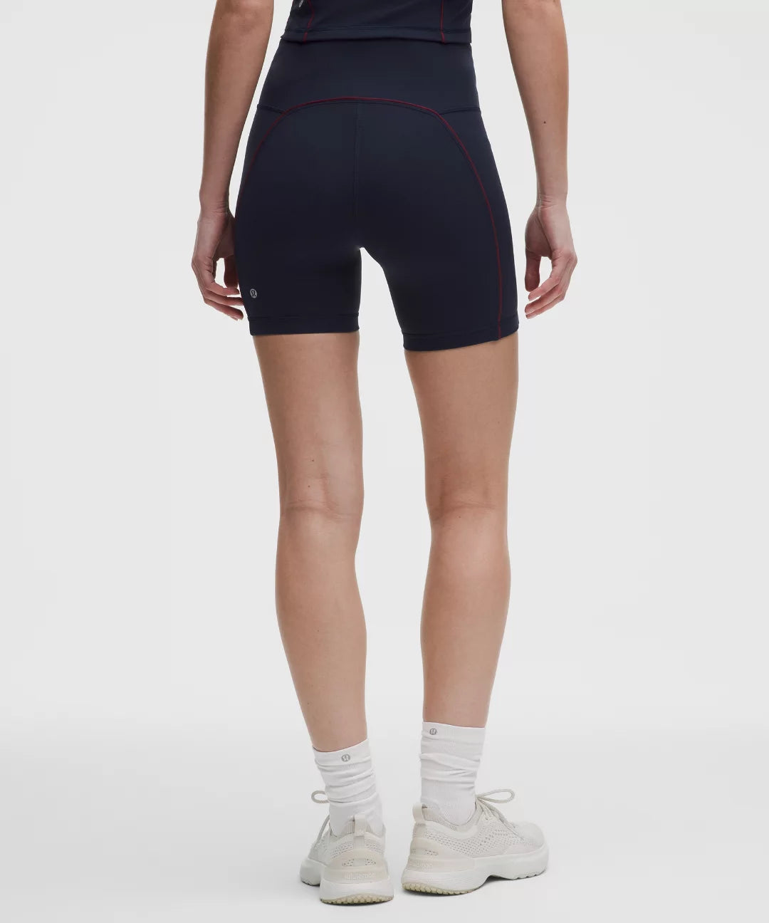 Person wearing black athletic shorts on a white background