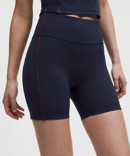 Navy blue athletic shorts with a red accent on a white background
