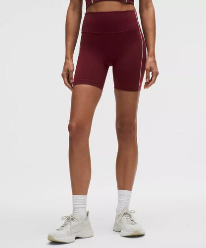 Person wearing maroon high-waisted athletic shorts on a white background