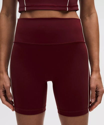 Maroon athletic shorts with a white stripe on a neutral background