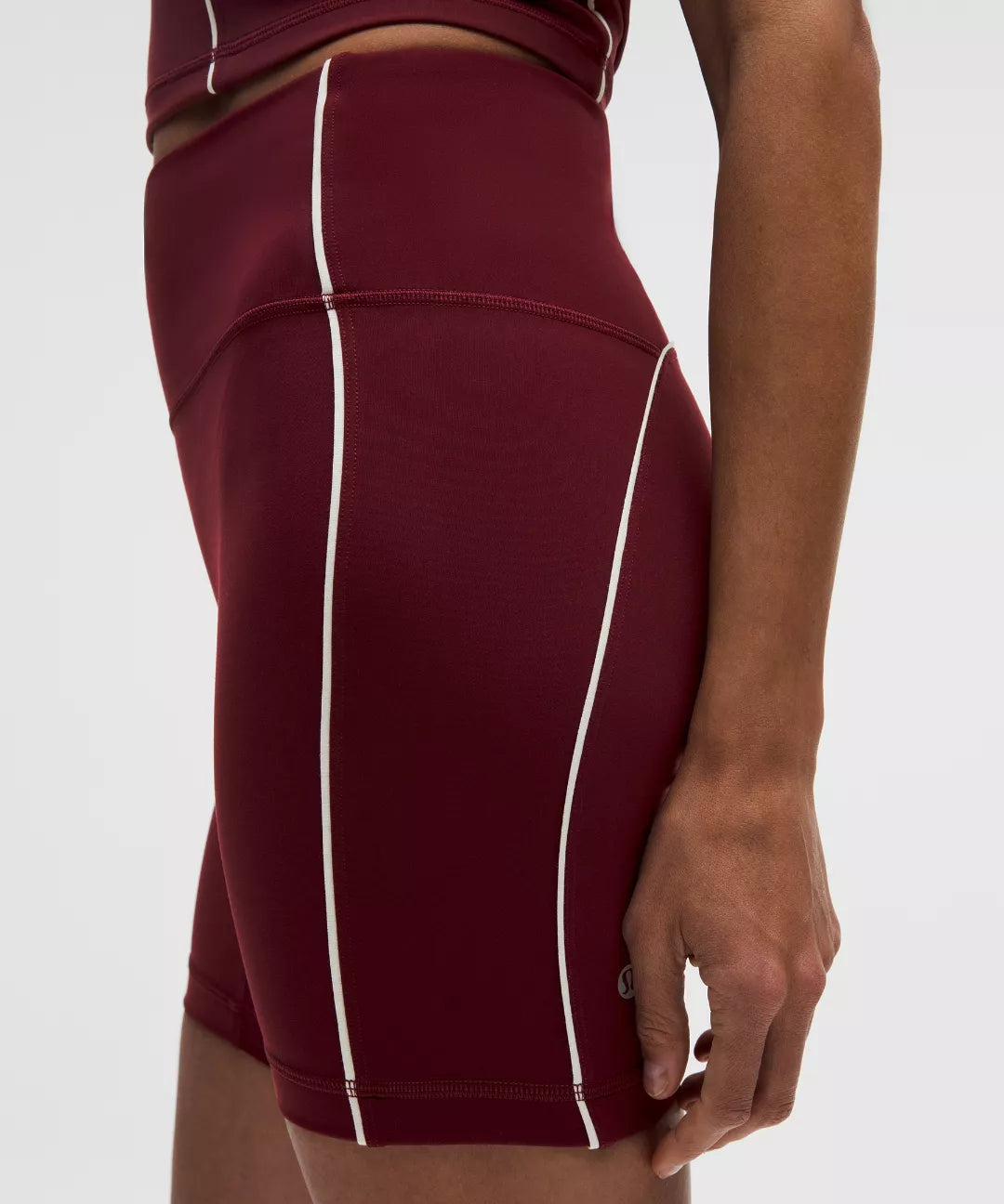 Maroon athletic skirt with white piping on a white background
