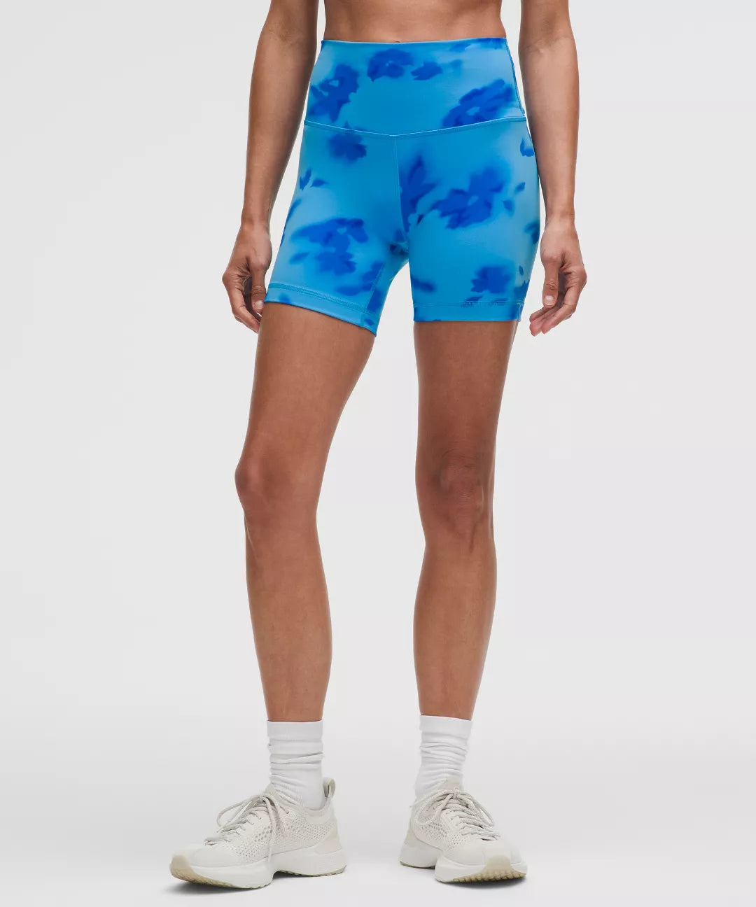 Person wearing blue tie-dye shorts on a white background