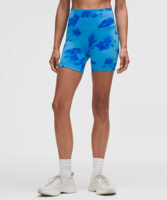 Person wearing blue tie-dye shorts on a white background