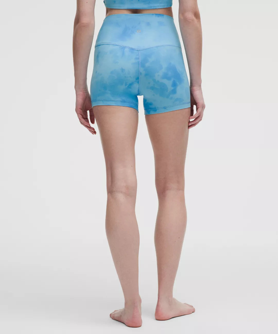 Person wearing blue tie-dye shorts on a white background